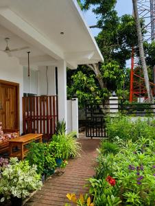 a patio with a bench and a bunch of flowers at Eastern Bay in Arugam Bay