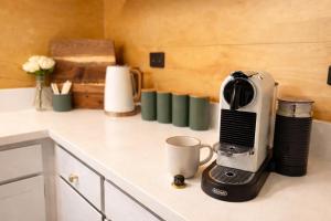a coffee maker sitting on a counter with a cup at Forest Hillside Glamping Retreat in Lochiel +15 photos