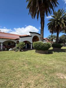 a house with two palm trees in a yard at La mansión in Salta