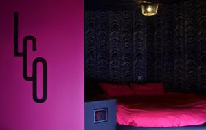 - une chambre dotée d'un lit avec un panneau rose dans l'établissement Le Clair Obscur, à Nantes