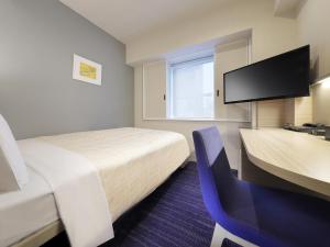 a hotel room with a bed and a desk and a tv at Keio Presso Inn Gotanda in Tokyo +17 photos