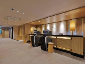 a hotel lobby with a reception desk and chairs at Keio Presso Inn Gotanda in Tokyo