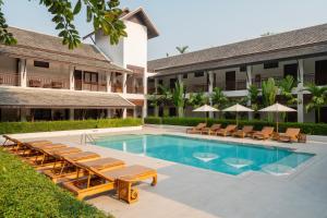 a swimming pool with lounge chairs and a resort at Rimping Village in Chiang Mai