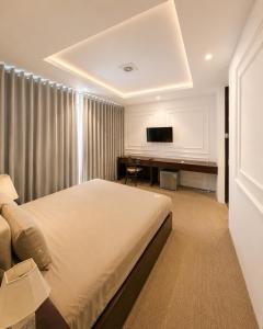 a bedroom with a bed and a desk with a television at X-Stay Cloud in Hai Phong