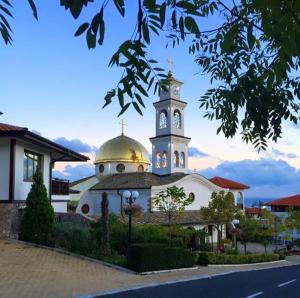 a large building with a clock tower on top of it at Siana 1 Apartment in Sveti Vlas