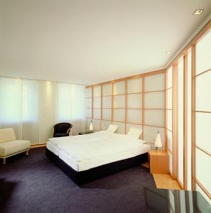 ein Schlafzimmer mit einem großen Bett und einem Stuhl in der Unterkunft Hotel Goldener Karpfen OHG in Fulda