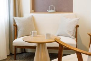 two coffee cups on a table next to a couch at JR-East Hotel Mets Kitakami in Kitakami