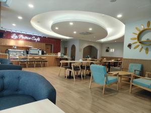 a restaurant with tables and chairs and a cafeteria at Country Hotel in Klang