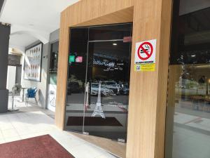 a sign in the window of a building with the eiffel tower at Country Hotel in Klang +13 photos