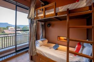 a bedroom with bunk beds and a balcony at Moustache Hostel Lonavala in Malavli