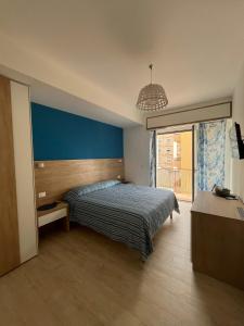 a bedroom with a bed and a blue wall at B&B Le Eolie in Milazzo