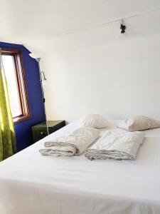 a bed with white sheets and pillows on it at Station Villa Vimmerby in Vimmerby