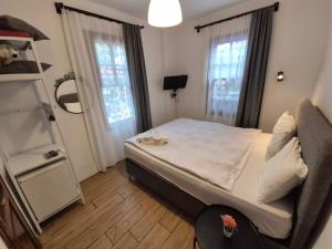 a small bedroom with a bed and windows at Sabah Pansiyon in Antalya