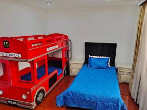 a childs bedroom with a red bus bunk bed at Casa cerca al Campín in Bogotá