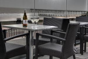 a bottle of wine sitting on a table with chairs at Best Western Hotel Hatfield in Lowestoft