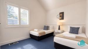 two beds in a small room with a window at Plover Executive Deluxe Villa 25 in Cams Wharf