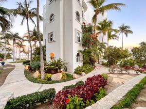 a building with palm trees and flowers in front of it at Mykonos Recently remodeled 1BR Beach Escape great view! in San José del Cabo
