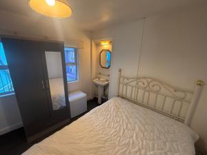 a bedroom with a bed and a sink and a mirror at Kinsale town centre 3 in Kinsale