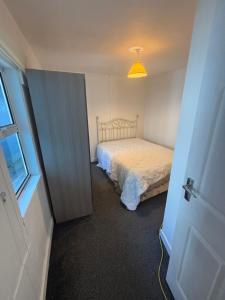 a small bedroom with a bed and a yellow light at Kinsale town centre 3 in Kinsale