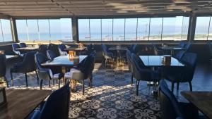 a restaurant with tables and chairs and a view of the ocean at Hotel Selenay in Istanbul