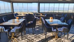 a restaurant with tables and chairs and a view of the beach at Hotel Selenay in Istanbul