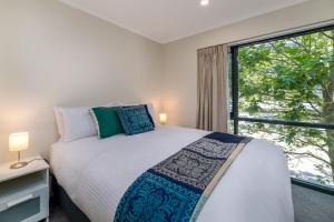 a bedroom with a bed and a large window at Central 2-bed Apartment with Gym and Spa in Canberra