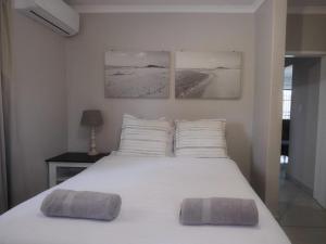 a bedroom with a white bed with two pillows on it at Uitspan No 5 in St Lucia