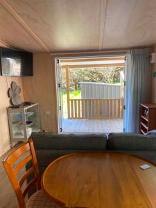 a living room with a couch and a wooden table at Hideaway Haven in Raglan