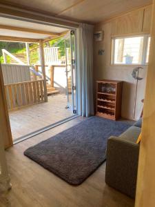 a living room with a couch and a sliding glass door at Hideaway Haven in Raglan