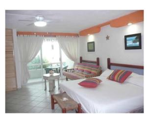 1 dormitorio con 1 cama y sala de estar en Cancun Beach ApartHotel by Solymar, en Cancún
