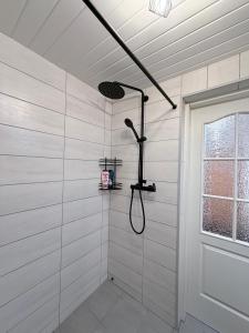 a shower in a white bathroom with a window at Alexandra Forest Lake House in Konsu +23 photos
