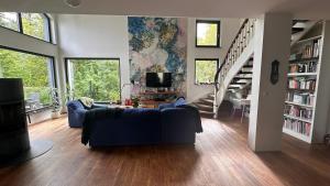 a living room with a blue couch and a tv at Dom przy Panke in Kolonie Röntgental