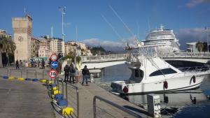 a boat is docked at a dock with a cruise ship at Piazzetta dei Consoli Apartment in Savona