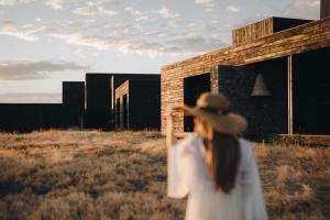 a woman in a hat walking in a field at Wood Hôtel & Spa in Saint-Gilles-les-Bains