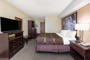 a hotel room with a bed and a flat screen tv at Super 8 by Wyndham Niagara Falls by the Falls in Niagara Falls