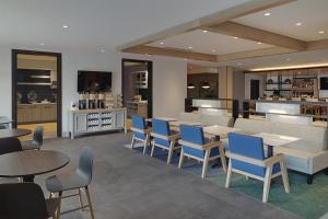 a restaurant with tables and chairs and a kitchen at Hyatt House Columbus OSU Short North in Columbus +85 photos
