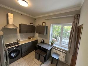 a kitchen with a stove and a sink and a window at Relax garden area with BBQ zone in Yerevan