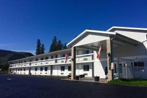 a large white building with flags in front of it at Super 8 by Wyndham Clearwater BC in Clearwater