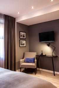 ein Schlafzimmer mit einem Stuhl und einem TV an der Wand in der Unterkunft Gasthaus Stappen in Korschenbroich