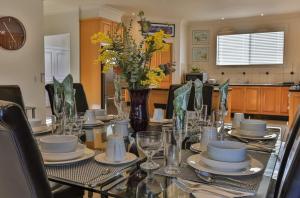 a table with plates and glasses and a vase with flowers at Phillip Island Dream Getaway in Ventnor +19 photos