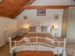 a bedroom with a white bed in a attic at Sycamore Vestry in Fishguard