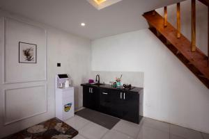 a kitchen with a small refrigerator and a staircase at Lovia Villa Dieng in Kejajar