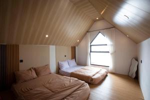 a bedroom with two beds and a window at Lovia Villa Dieng in Kejajar