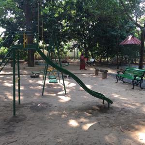 a playground with a green slide in a park at Palm Grove Service Villa in Cochin