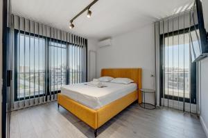 a bedroom with a bed and large windows at Studio București in Bucharest