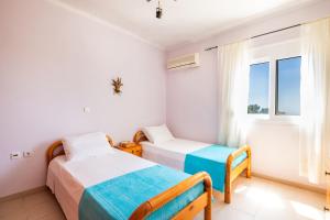 a bedroom with two beds and a window at Miraluna View in Mesochórion