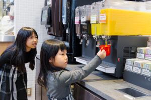 two young girls are standing at a counter in a store at Richmond Hotel Nagoya Nayabashi in Nagoya