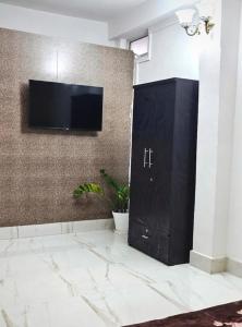 a black door with a tv on a wall at DZ Homestay 1BHK in Dimāpur