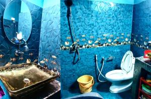 a blue bathroom with a sink and a toilet at DZ Homestay 1BHK in Dimāpur +5 photos