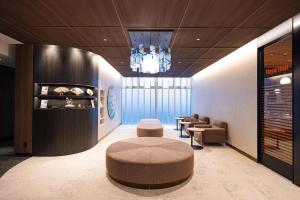 a waiting room with a chair and a circular stool at Richmond Hotel Nagoya Nayabashi in Nagoya